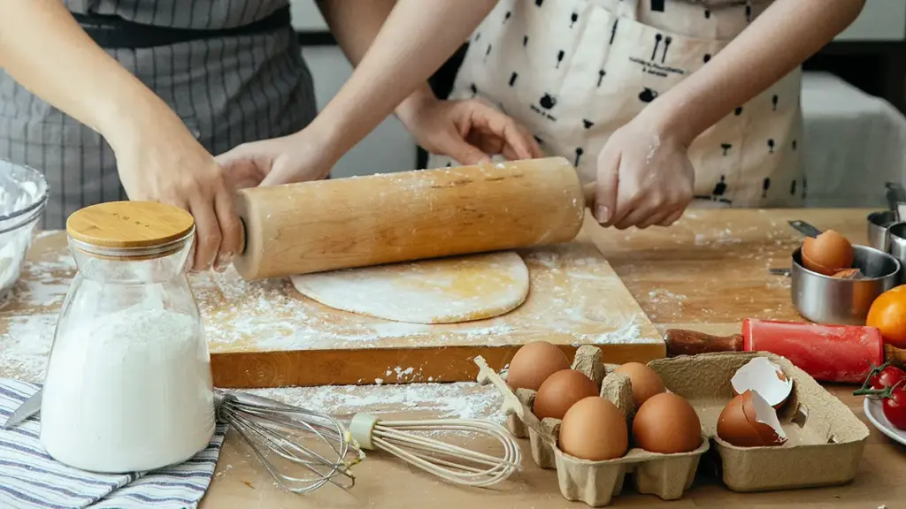 Two women using a rolling pin
